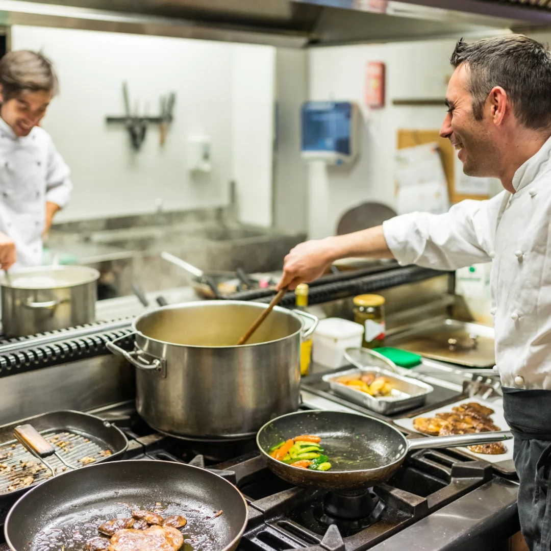 Chef y cocinero en el trabajo en la cocina de un restaurante